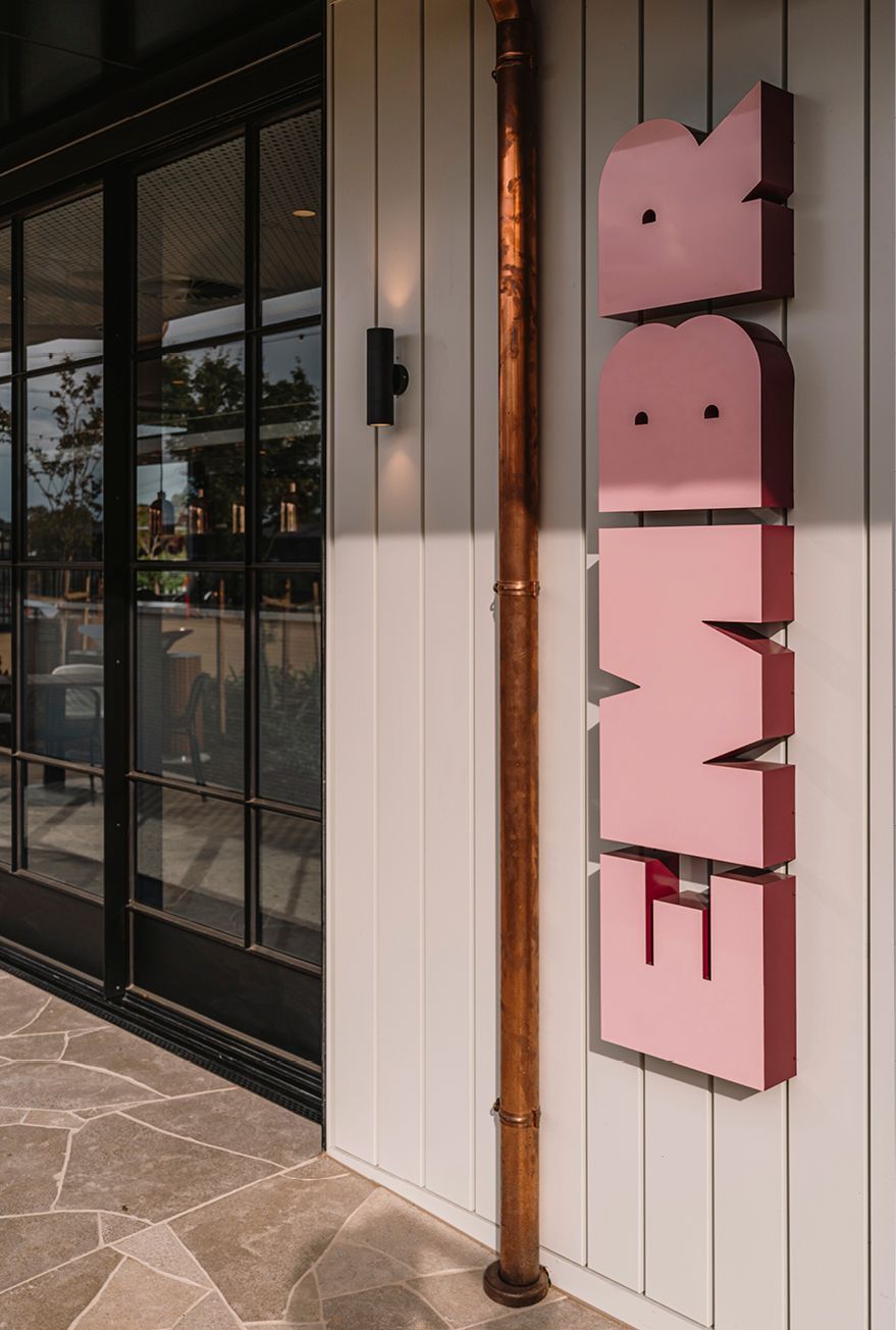 Crafted details include oversized signage, copper downpipe and furnished waiting space