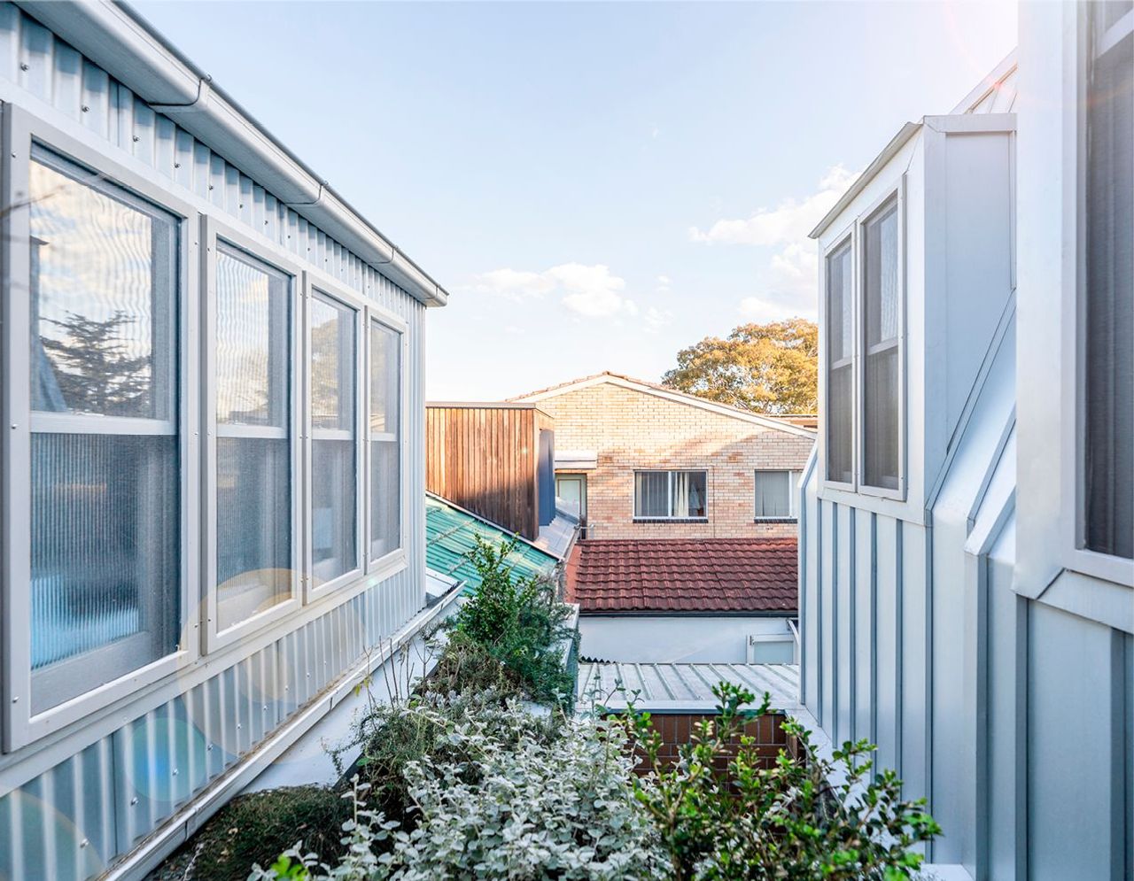 Left side renovated original cottage roof pavilion and right side extension roof pavilion with small courtyard in between